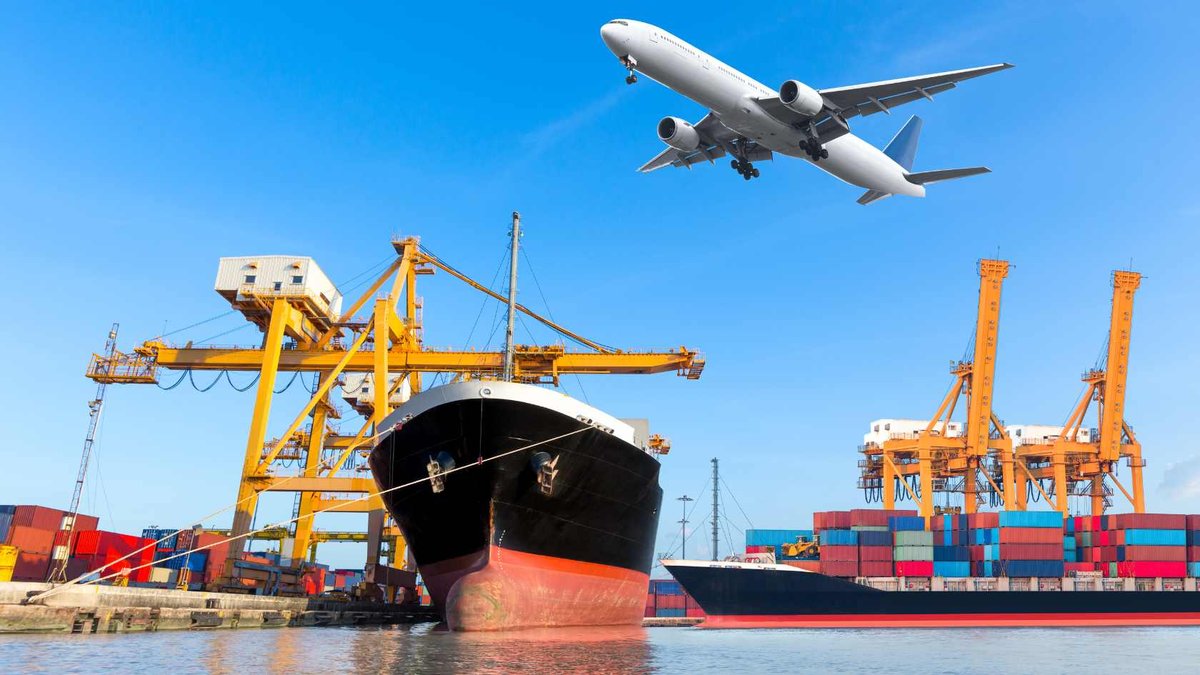 Container ship under gantry cranes with aircraft overhead